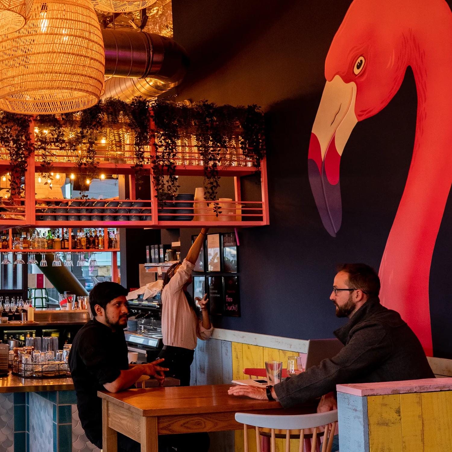 Inside, Flamingo Joe’s, a restaurant and bar with people eating and drinking and staff members working.