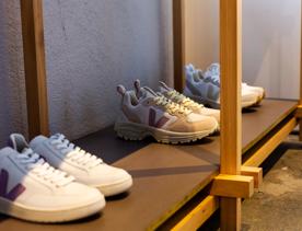 3 pairs of Veja shoes on a wooden shelf inside Kowtow.