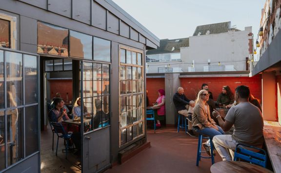 People enjoying drinks on the rooftop terrace at Ascot in Wellington.