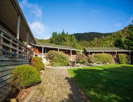 Camp Wainuiomata screen location. Has several buildings and is surrounded by forest and bush.