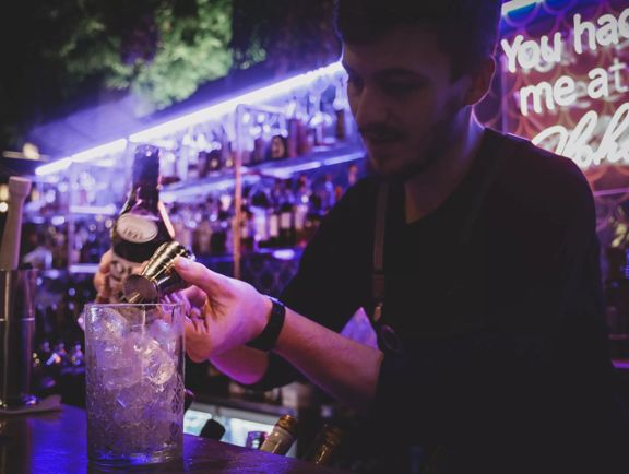 Close up of bar tender at Lulu creating a cocktail.