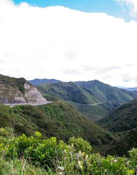 The screen location of Remutaka Summit, wit views of surrounding peaks, lush green bush and steep roads cut into the sides of the mountains.