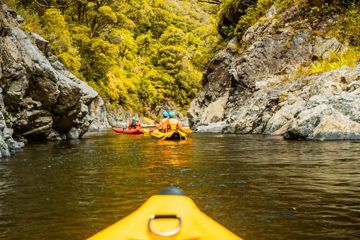 People kayaking down a river.