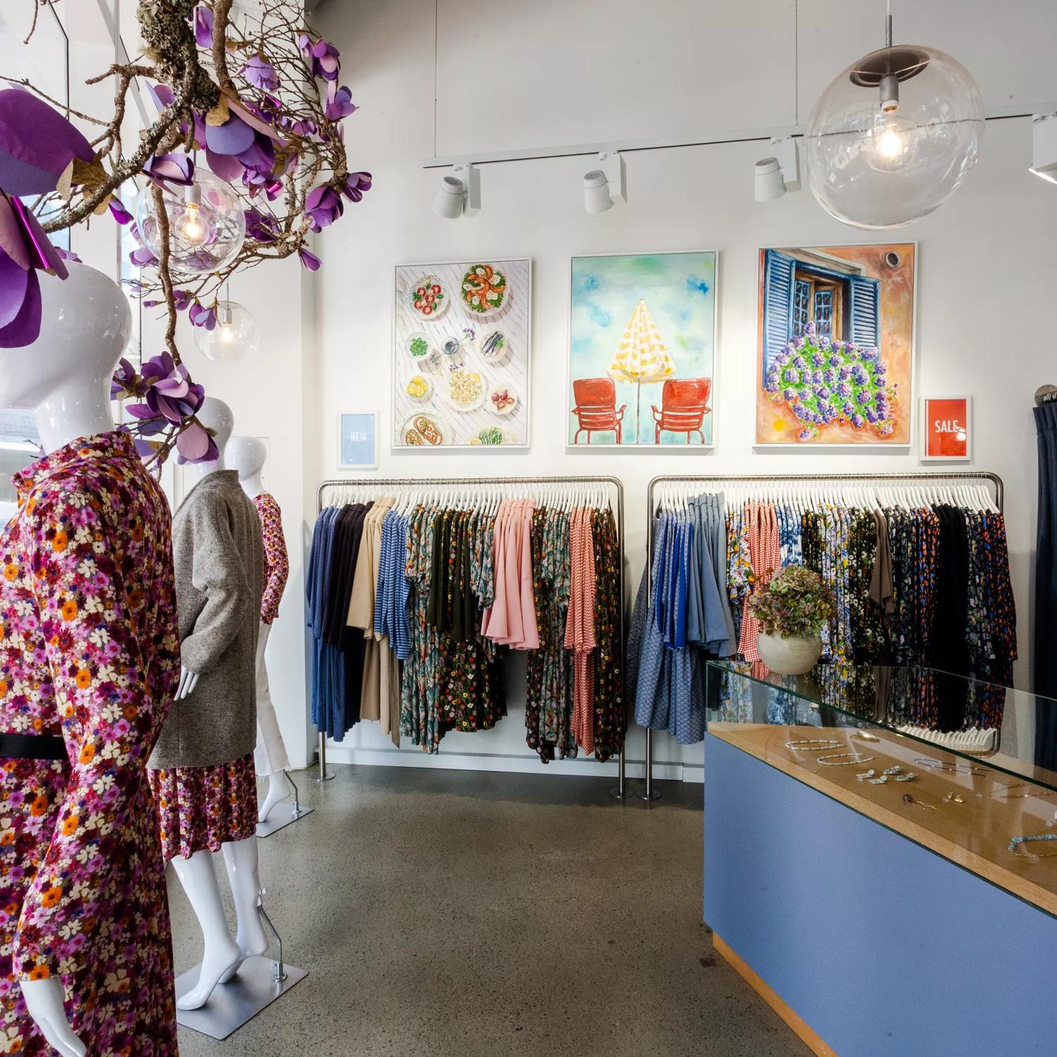 Inside Wilson Trollope, mannequins are seen in front of the large glass windows, racks of clothes adorn the walls and the counter has jewellery inside a glass case.