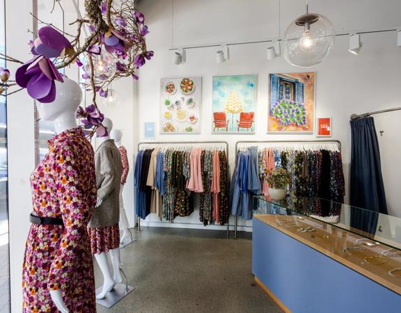 Inside Wilson Trollope, mannequins are seen in front of the large glass windows, racks of clothes adorn the walls and the counter has jewellery inside a glass case.