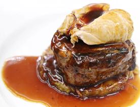 super close up of a fillet dish with gravy and potato.