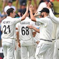 BLACKCAPS cricket players high-fiving on the pitch.