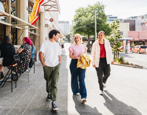 Three people walk along Swan Lane outside Best Ugly Bagels.