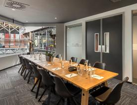 A private meeting room inside Oaks Wellington Hotel, where 14 chairs sit around a long table.