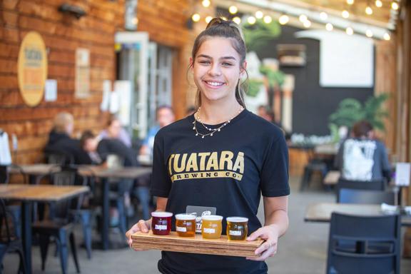 A waiter holding a tasting tray of beers at Tuatara.