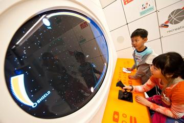 Children are playing on a spaceship driving simulator at Space Place at Carter Observatory.