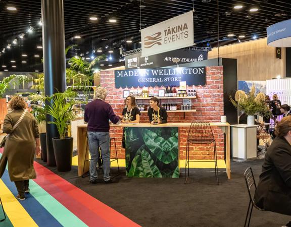 The Tākina stall set up at a convention, with people walking around.