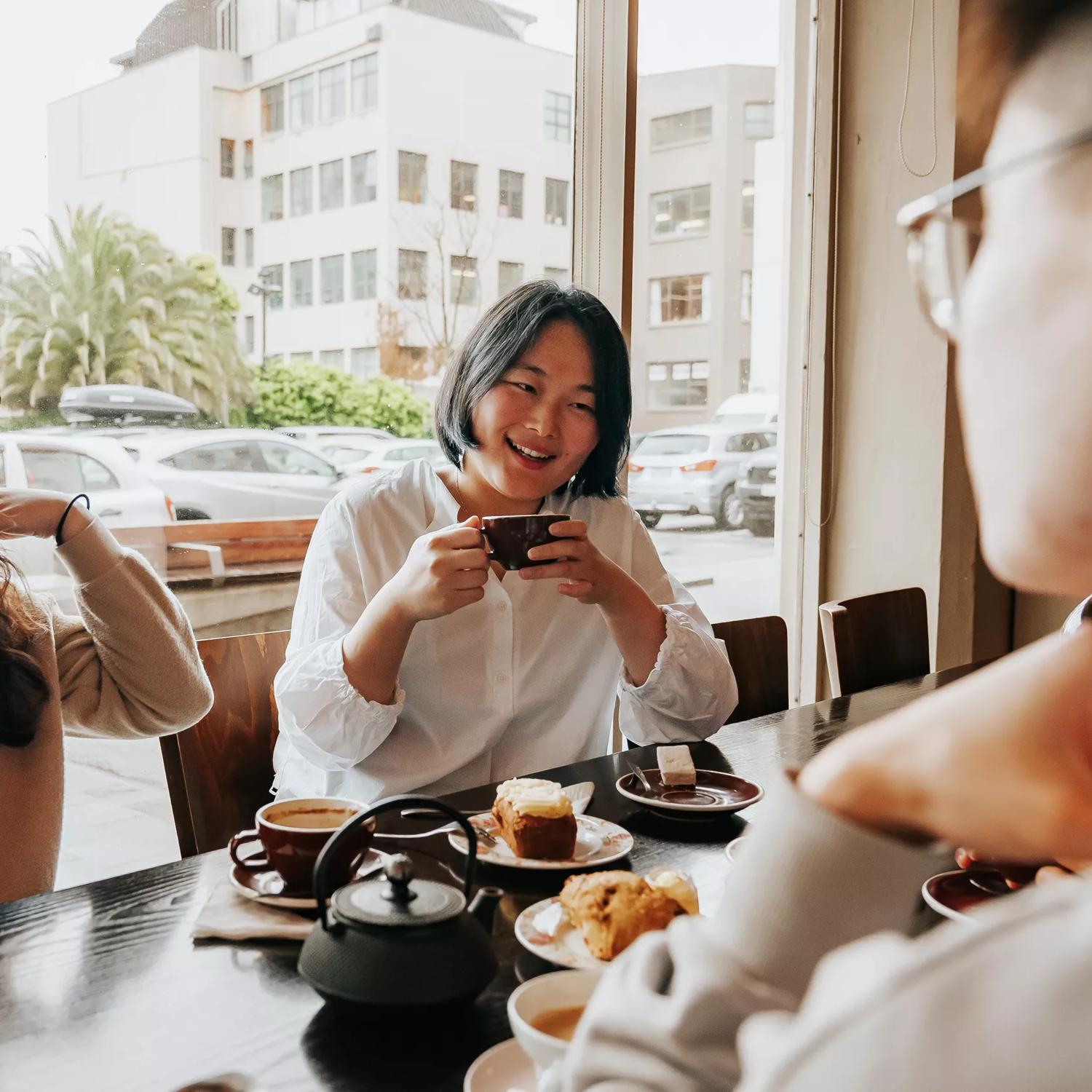 Three friends chat over coffee and pastries at Floriditas.