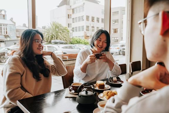Three friends chat over coffee and pastries at Floriditas.