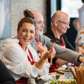 People are seated at a table eating at House of Dumplings located on Taranaki Street, Te Aro, Wellington.