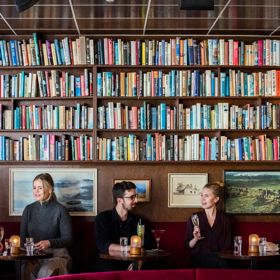 Five people enjoy cocktails at The Library, a hidden bar on Courtenay Place in Wellington.
