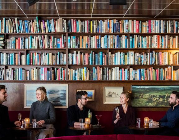 Five people enjoy cocktails at The Library, a hidden bar on Courtenay Place in Wellington.