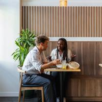 Two friends chat over food and drinks at Hei, a modern Chinese restaurant on Cuba Street in Wellington.