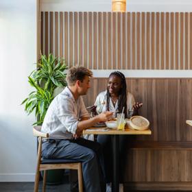 Two friends chat over food and drinks at Hei, a modern Chinese restaurant on Cuba Street in Wellington.