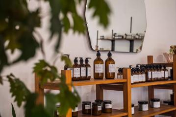 Brown bottles of moisturiser and candles are on display shelves at Wellington Apothecary.