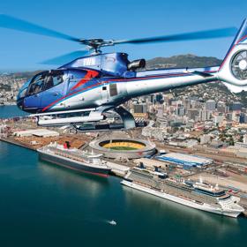 A helicopter flying over the Wellington Harbour with the city centre visible in the background.