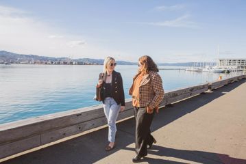 Prologic Skincare Founder Rachel Robertson and her mentor, Pieta Reid, walk along Wellington's waterfront on a sunny day.