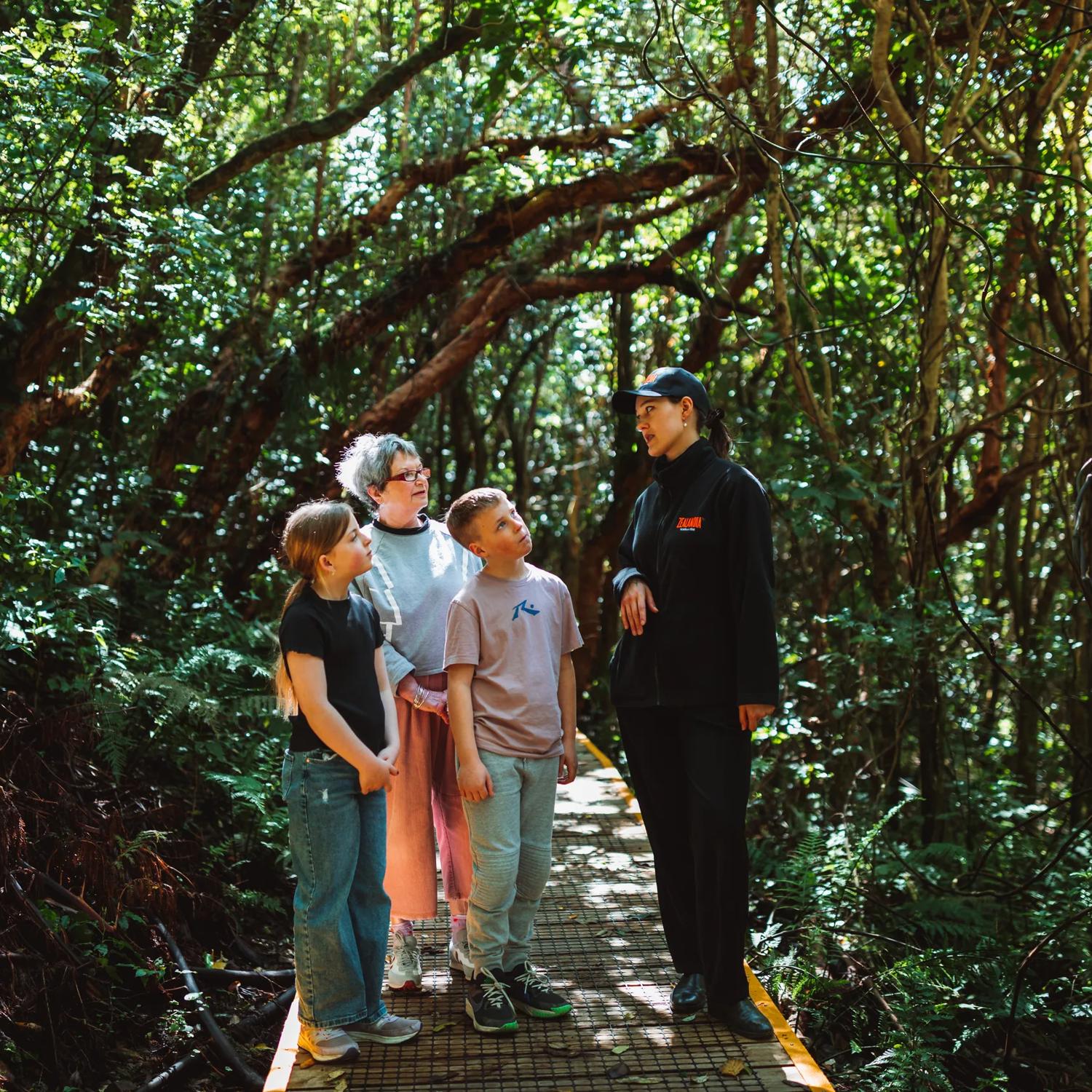 A family of three is on a guided walking tour at Zealandia.