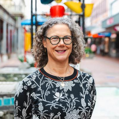 Headshot of Tracey Bridges, a board member of WellingtonNZ, smiling in front of the Bucket Fountain.