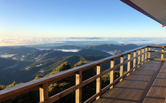 The view of mountain ranges from a wooden deck.