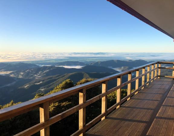 The view of mountain ranges from a wooden deck.