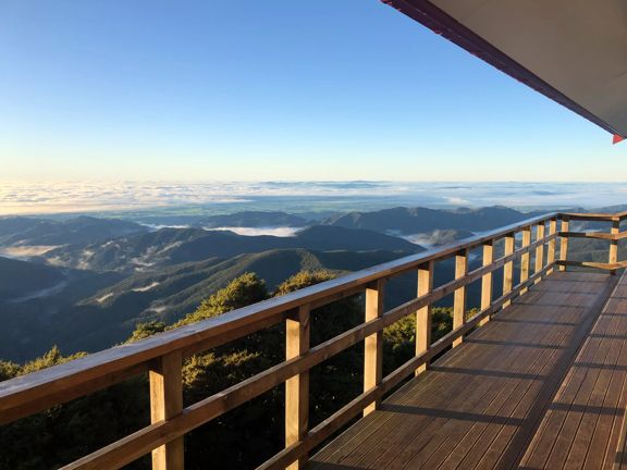 The view of mountain ranges from a wooden deck.