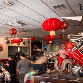 Inside a busy Chinese restaurant with red lanterns suspended from the ceiling.