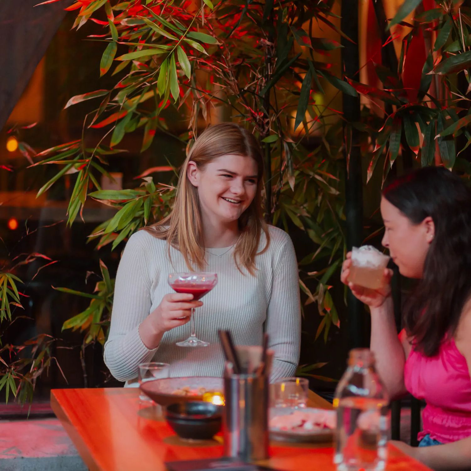 Two people drinking from cocktails in Dragonfly, a bar on Courtenay Place.