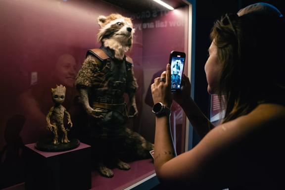 A person taking a picture of the Rocket Racoon and Groot from the Guardians of the Galaxy franchise at Marvel: Earth's Mightiest Exhibition at Tākina.