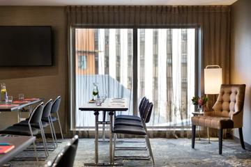 2 tables next to a large window inside the Rosa room.