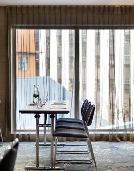 2 tables next to a large window inside the Rosa room.