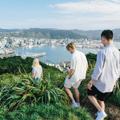 Three people walking at the summit of Mount Victoria with a view of Wellington city in the background.