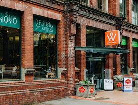 Exterior of YOYO Design by Kiwi’s storefront in Wellington, featuring a red brick façade, large display windows, and street-facing signage above the entrance.