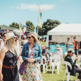People walking together in the sunshine at the Kāpiti food fair.