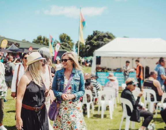 People walking together in the sunshine at the Kāpiti food fair.