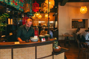 The host at Apachè stands behind the front desk.