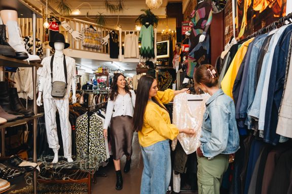 People browsing and shopping among racks of vintage clothing at Hunters & Collectors in Wellington.
