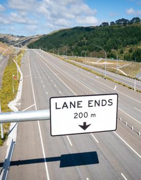 The 4 lane motorway of Transmission Gully, surrounded by green hills.