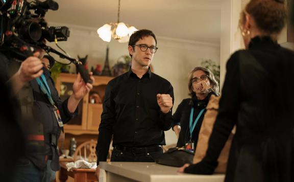 Behind the scenes of the Mr. Corman TV show. Joseph Gordon-Levitt directs Lucy Lawless in a kitchen surrounded by film crew.