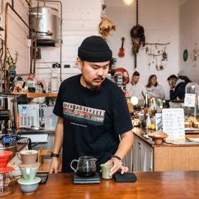 Barista at pour and twist creating their custom coffee on the counter.