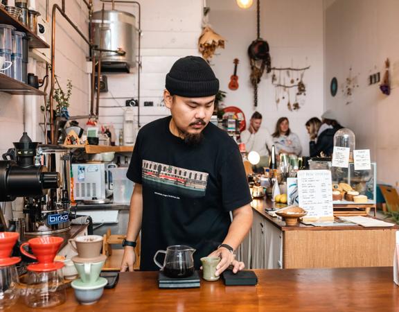Barista at pour and twist creating their custom coffee on the counter.