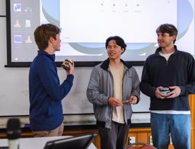 Three marketing students at Victoria University give a presentation in a lecture hall.