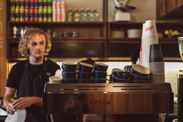 Barista stands behind a coffee machine at Customs on Ghuznee street.