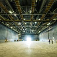 Inside the K Stage at Stone Street Studios. It is a large space with a concrete floor and a grid of catwalks on the ceiling.