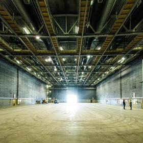 Inside the K Stage at Stone Street Studios. It is a large space with a concrete floor and a grid of catwalks on the ceiling.